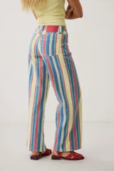 Pantalón wide leg de denim con diseño de rayas verticales multicolor en tonos amarillo, rojo y azul.