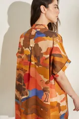 Vestido corto de lino blanco con estampado artístico de paisaje costero, cuello mao y mangas cortas holgadas.