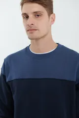 Sweater deportivo de hombre con escote redondo, diseño colorblock con la parte superior en gris claro y el cuerpo y mangas en negro. Presenta puños y cintura elastizados.