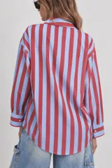 Camisa de manga larga con diseño de rayas verticales en tonos rojo y celeste, corte holgado y cuello con lazo incorporado para atar.