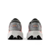 Championes de running New Balance FuelCell Rebel v5, color gris con detalles en naranja y suela blanca.