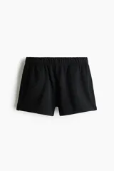 Short en tejido de felpa color negro, con interior cepillado suave, cintura elástica, bolsillos laterales insertados y abertura corta en los bajos.