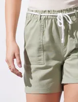 Short color crema con finas rayas verticales grises, pretina elastizada con cordón de ajuste, bolsillos delanteros y traseros.