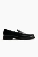 Mocasines de diseño clásico en color negro, con costura tradicional en la parte superior y suela de goma.