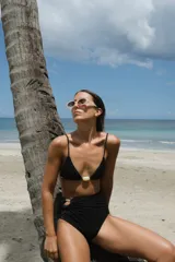 Top de bikini modelo triángulo color verde azulado oscuro (petrol) con tejido texturizado. Presenta copas de relleno removibles, breteles regulables y una pieza decorativa central de resina color ámbar/naranja.