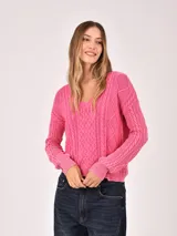 Buzo de tejido de punto color verde menta, con cuello en V y diseño de trenzas en el frente y mangas. Presenta un efecto desgastado o lavado.