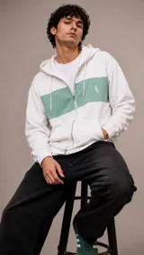 Campera con capucha y cierre frontal, de diseño color block en blanco y verde menta. Presenta un pequeño logo bordado en el pecho y bolsillos tipo canguro.