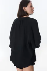 Camisa marrón de lino con cuello mao, mangas largas y corte holgado.