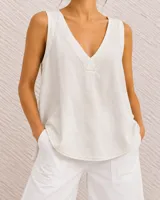 Musculosa de lino color beige, sin mangas, con escote en V y costuras pespunteadas en contraste.