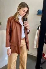 Blazer de cuero sintético color chocolate con cuello solapa y bolsillos con tapa.
