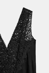 Vestido midi de viscosa color negro con escote en V y aplicaciones de encaje a tono en los tirantes y el pecho, de silueta evasé.