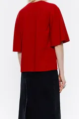 Camiseta blanca de corte holgado con mangas cortas acampanadas.