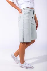 Bermuda de jean celeste lavado, de corte relajado, largo a la rodilla y terminaciones desflecadas.