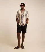 Bermuda básica masculina confeccionada en sarga de algodón, de corte recto con trabillas en la cintura, bolsillos y cierre frontal con botón y cremallera.