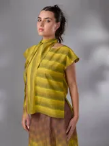 Blusa sin mangas de lino y algodón, con diseño a rayas en tonos amarillos y verdosos, escote en V y cuello alargado estilo bufanda para anudar.
