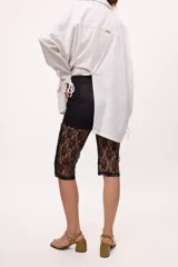 Pantalón capri negro de encaje con calza interior.