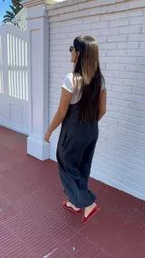 Mono largo de lino color beige, con breteles finos ajustables que se atan en la espalda, corte holgado y bolsillos laterales.