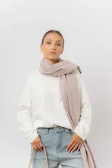 Bufanda tejida de textura suave y liviana, con terminación de flecos en los extremos.
