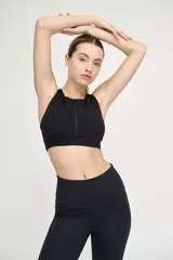 Top deportivo negro con cuello alto y cierre frontal.