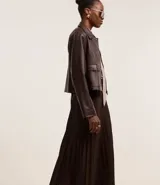 Falda midi marrón de cuero sintético con cintura sastre y textura plisada.