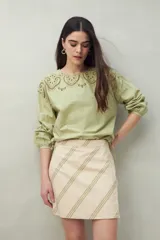 Minifalda de algodón color beige con estampado de rayas diagonales verdes.