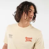 Remera de manga corta color beige, con cuello redondo y estampado frontal con la inscripción "Sunset Drive" y detalles tipográficos en el pecho.