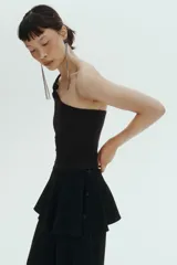 Body negro con escote asimétrico de un hombro, bretel ancho con detalle de nudo y diseño colaless.