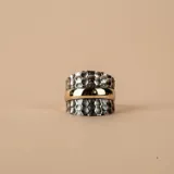 Anillo ancho de diseño mixto, compuesto por una banda central lisa de oro amarillo flanqueada por dos bandas laterales de plata 925 con acabado martillado.