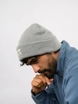 Gorro de lana gris, de punto acanalado con vuelta y parche frontal con el logo de Umbro.