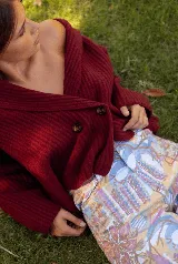 Saco de punto acanalado color bordó, con solapas anchas, cierre frontal cruzado con dos botones y mangas largas de corte holgado.