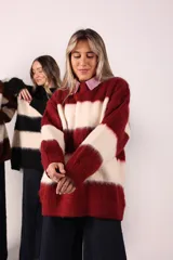Buzo de lana marrón con rayas horizontales blancas, de corte amplio y cuello redondo.