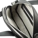 Cartera tipo baúl negra de cuero graneado con doble asa corta y correa larga regulable y desmontable. Tiene cierre superior, dos compartimentos internos y un bolsillo interno con cierre. Los herrajes son plateados y el interior es de tela de algodón y poliéster.