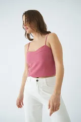 Top corto de dama con tirantes finos ajustables, confeccionado en tejido de textura natural con costuras decorativas en el frente y grifa de cuero.