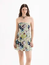 Vestido corto de silueta strapless y calce ajustado, confeccionado en encaje estampado con diseño floreado sobre base amarilla. Está forrado íntegramente en poplín y presenta recortes de entalle en el delantero y la espalda.