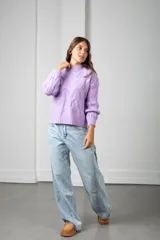 Sweater de punto color lila, con cuello redondo y diseño trenzado en relieve. Presenta mangas largas con puños acanalados y un corte holgado.