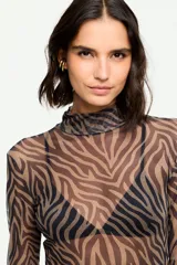 Blusa de tul semitransparente con estampado animal print tipo cebra en tonos marrón y negro, cuello alto y mangas largas.