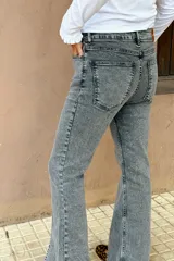 Jean de corte wide leg en color gris con efecto lavado. Presenta tiro medio-alto, costuras verticales frontales y tajos en el ruedo de ambas piernas.