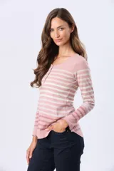 Remera de manga larga con cuello redondo y cierre frontal parcial con botones. Presenta un diseño de rayas horizontales en tonos pastel sobre una base beige, con aberturas laterales en el ruedo.