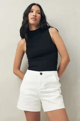 Short de tiro medio y calce ajustado, color blanco, con dobladillos en las piernas y cierre frontal con botón.