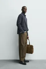 Pantalón de corte recto confeccionado en denim de algodón rígido con efecto lavado. Presenta tiro medio, cierre frontal con cremallera y botón, y diseño clásico de cinco bolsillos.