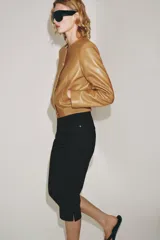Campera bomber de cuero 100% color tostado de la ZARA WOMAN COLLECTION, con cuello redondo, manga larga, bolsillos delanteros ribeteados y cierre frontal con botones metálicos en relieve. Presenta elástico fruncido en el dobladillo inferior.