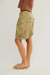 Short de sarga de algodón lavada verde militar, de tiro bajo, con silueta barrel, bolsillos y cierre frontal con botón.