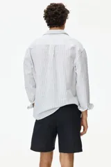 Short negro de corte regular fit, confeccionado en mezcla liviana de lino y algodón. Posee cintura elástica con cordón de ajuste, bragueta con botón, bolsillos en las costuras laterales y un bolsillo ojal en la parte posterior.
