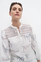 Camisa blanca estampada con palmeras y bordados en azul.