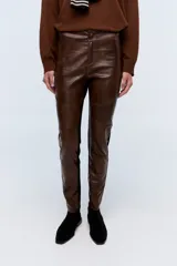 Pantalón calza marrón con frente de cuero sintético y parte trasera de tela elástica negra.