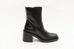 Bota de caña media color negro, de cuero, con punta cuadrada y taco bloque.