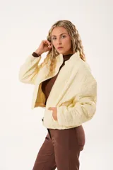 Campera color manteca con diseño acolchado de flores, cuello alto, cierre frontal con cremallera y bolsillos laterales.