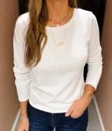 Remera de algodón de manga larga, color blanco, con cuello redondo y corte clásico.