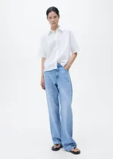 Camisa de manga corta con cuello camisero y cierre frontal de botones. Confeccionada en una mezcla de lino y algodón, presenta un diseño recto y minimalista.