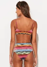 Conjunto de bikini Triya Lia con corpiño triangular de breteles finos y bombacha de tiro alto, ambos con estampado de rayas horizontales multicolores.